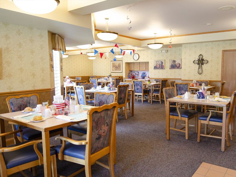 An inviting dining room with neatly arranged tables and chairs, decorated for an event.