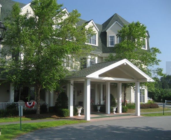 A welcoming hotel entrance with a canopy surrounded by greenery.