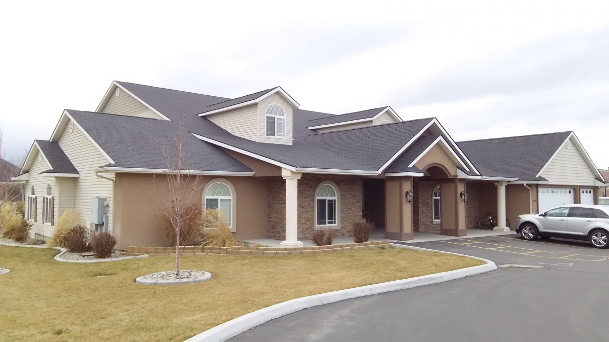 A view of a suburban residential house with a pitched roof and well-maintained surroundings.
