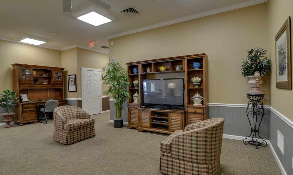 A cozy living room with a large television, comfortable seating, and thoughtful decor.