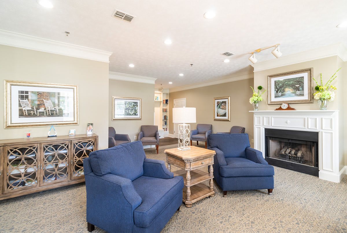 A cozy living room with blue armchairs and a fireplace.
