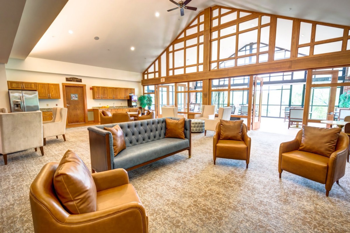 A spacious lobby area featuring modern furniture, large windows, and wooden beams.