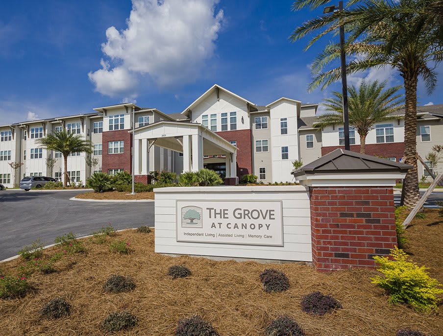 Exterior view of The Grove Senior Living facility with its prominent entrance and surrounding landscaping.