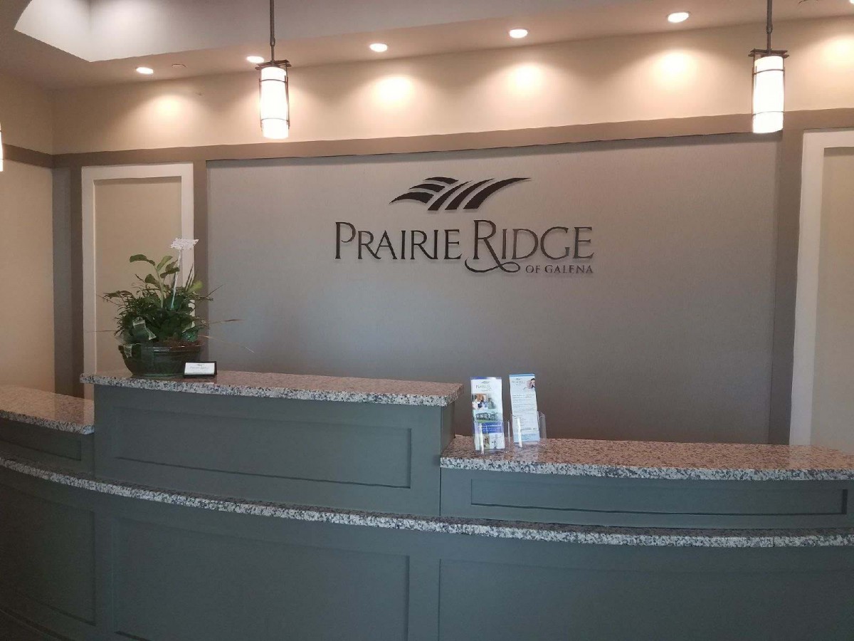 A modern reception area with a Prairie Ridge sign and contemporary lighting.