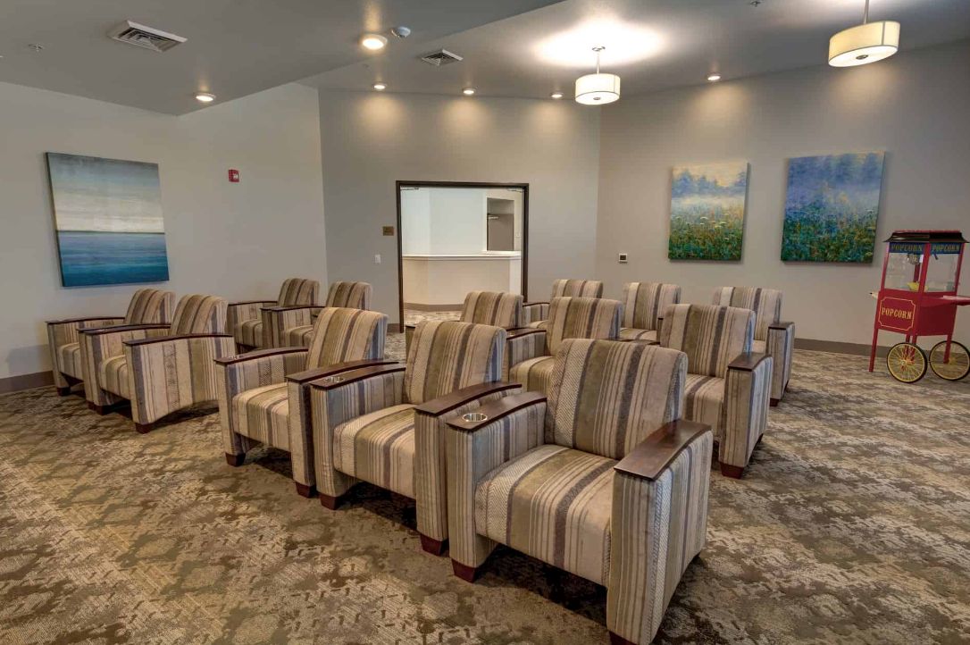A modern conference room with rows of striped upholstered chairs.