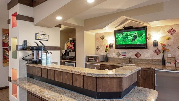 A modern restaurant interior featuring a bar counter with a television.