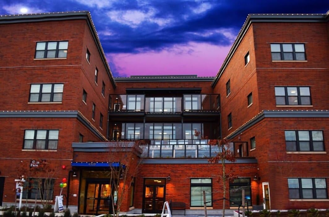 A red brick building set against a colorful evening sky.