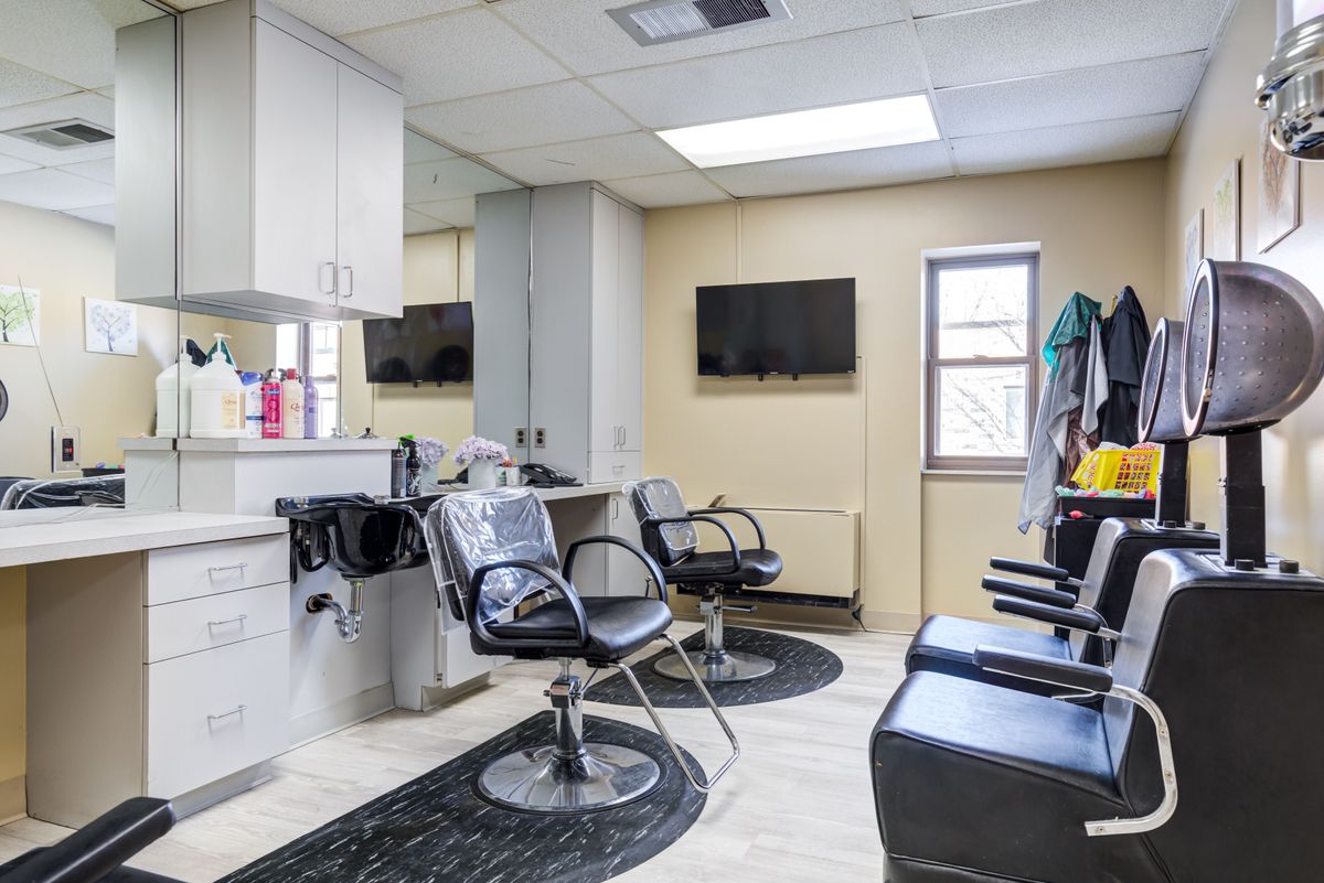 A modern salon interior with styling chairs, mirrors, and televisions.