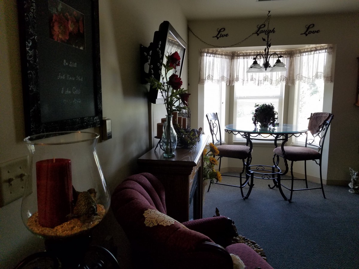 A cozy living and dining area with elegant furnishings and large windows allowing natural light.