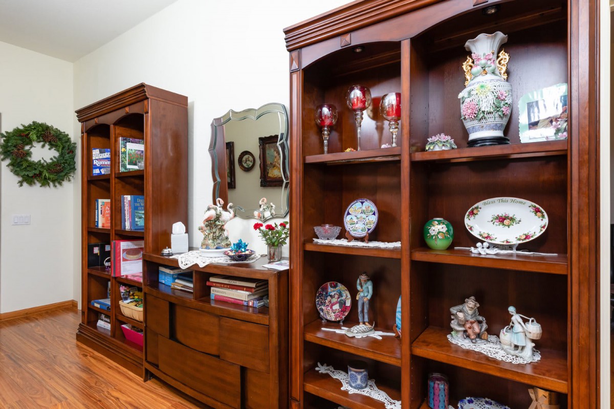 A well-decorated room showcasing wooden shelves filled with decorative vases, plates, and various home decor items.