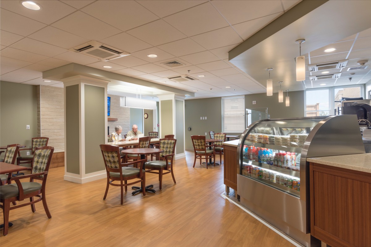 A modern cafe interior with dining tables and a display counter.