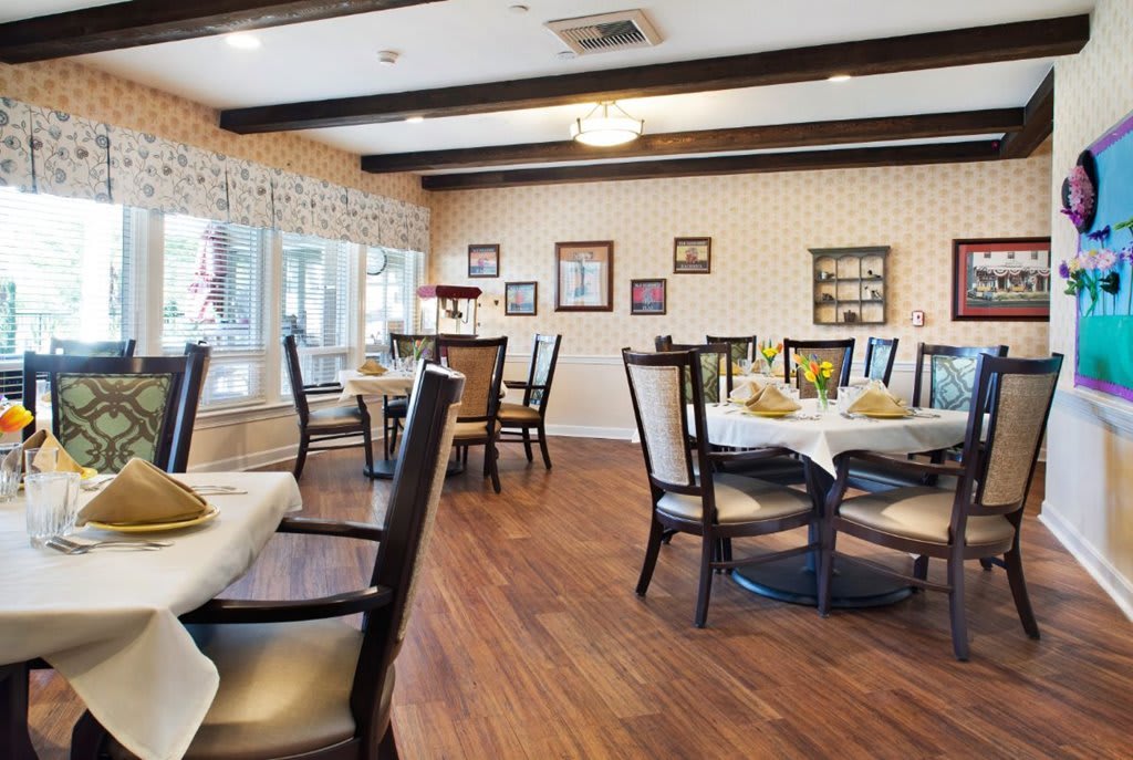 A cozy dining room with elegantly set tables and comfortable chairs.