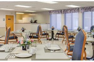 A well-arranged dining area with neatly set tables, decorated with flowers.