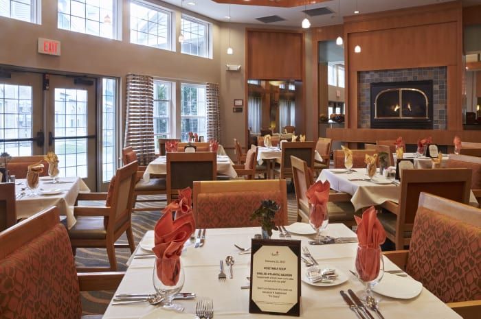 An elegant restaurant dining room with neatly set tables and chairs.