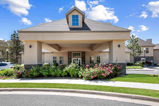 A charming residential building featuring a beautiful garden in front.