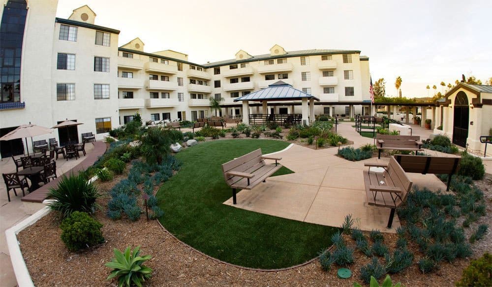 A well-landscaped exterior view of a residential building with a central garden and pathways.
