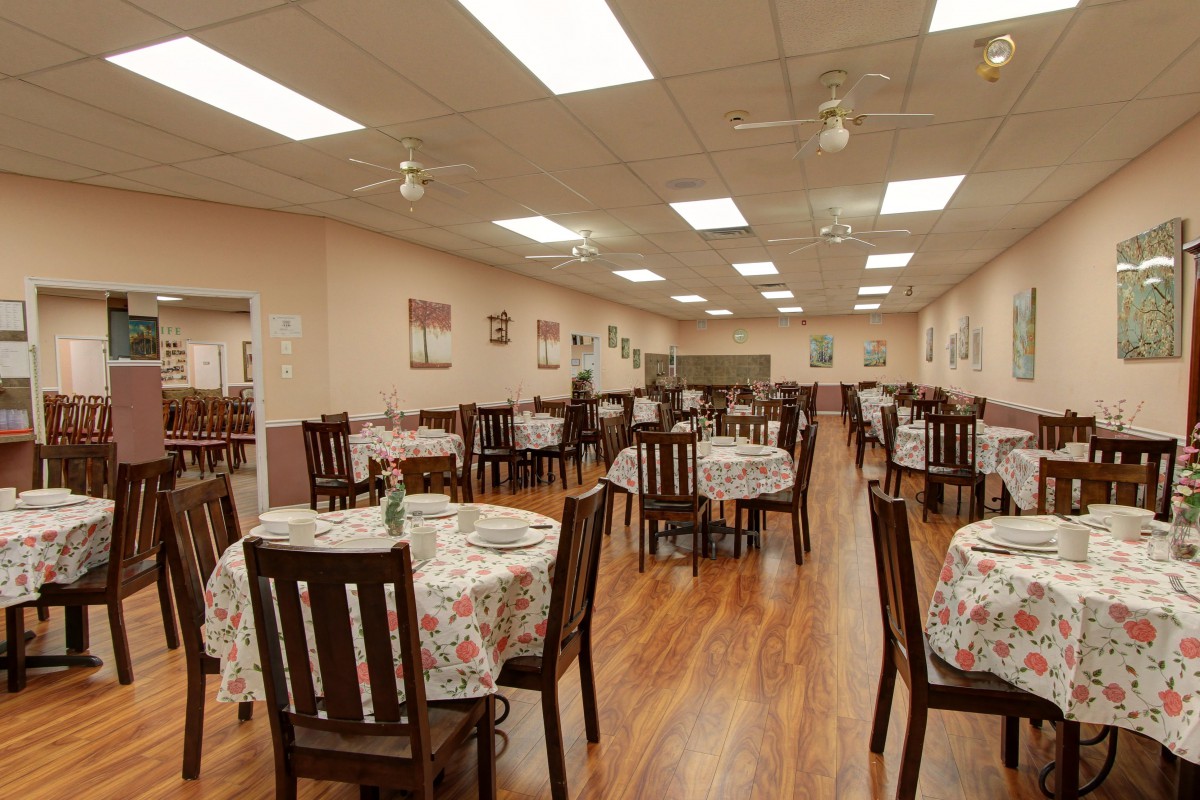An empty restaurant dining area with neatly arranged tables and chairs.