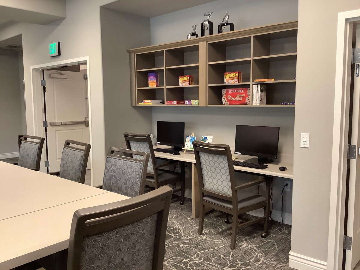 A modern office workspace with computers and shelving units.