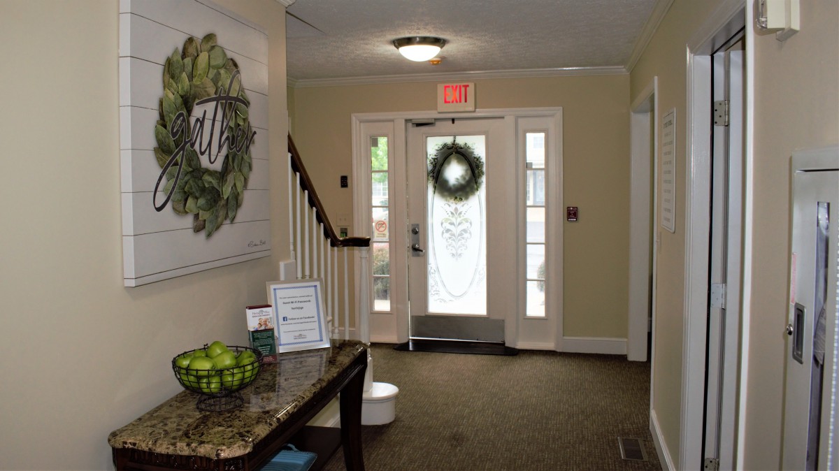 A well-decorated entrance with a wreath on the door and a staircase leading to the upper floor.