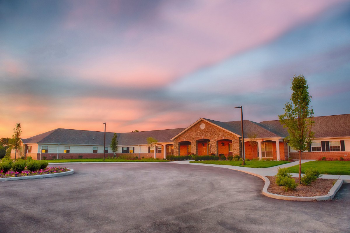 A picturesque view of a residential building with a sunset backdrop.