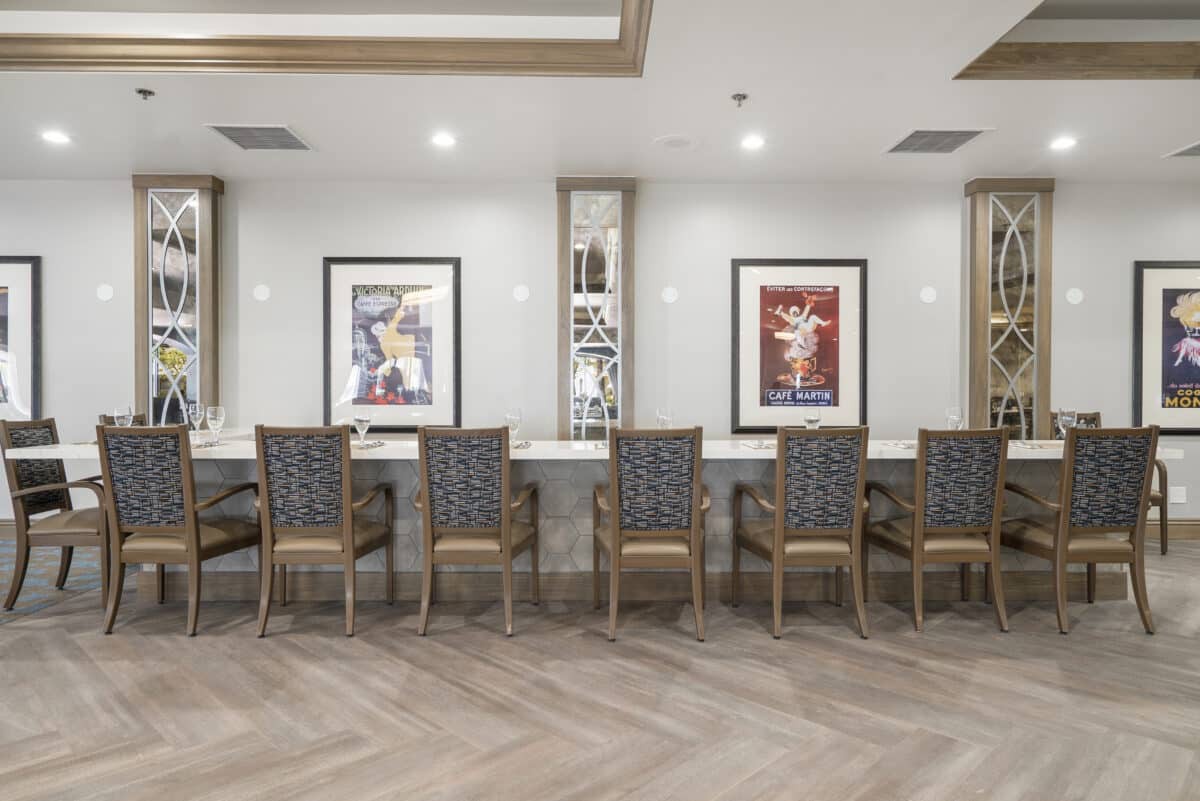 A modern office waiting area with chairs and framed artwork on the walls.