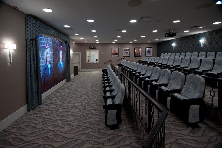 A modern auditorium with rows of seats and a large screen at the front.