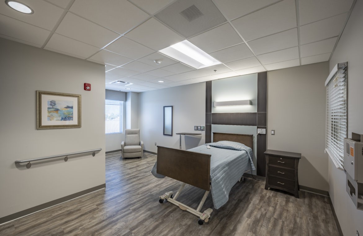 A clean and modern hospital room with a patient bed and medical equipment.