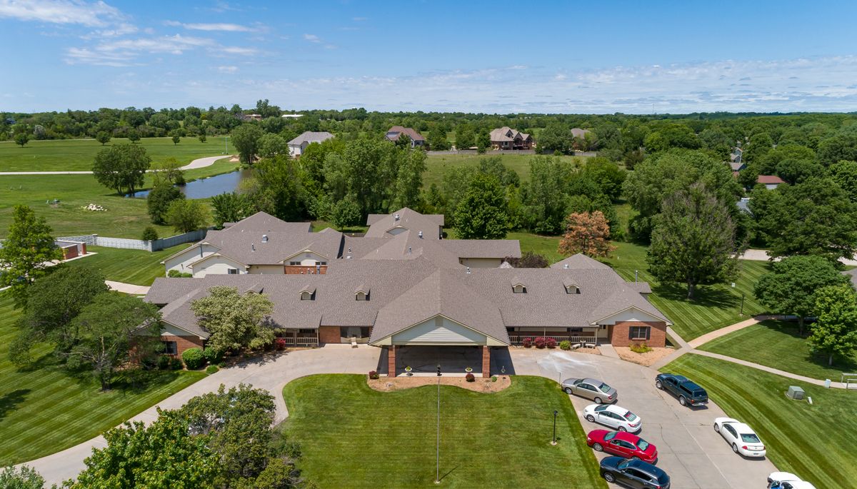 Aerial view of a large residential building surrounded by greenery.