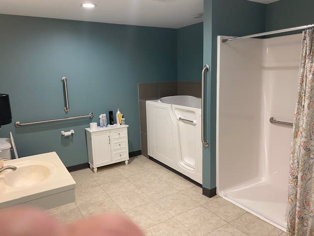 An accessible bathroom featuring a walk-in bathtub and shower area.