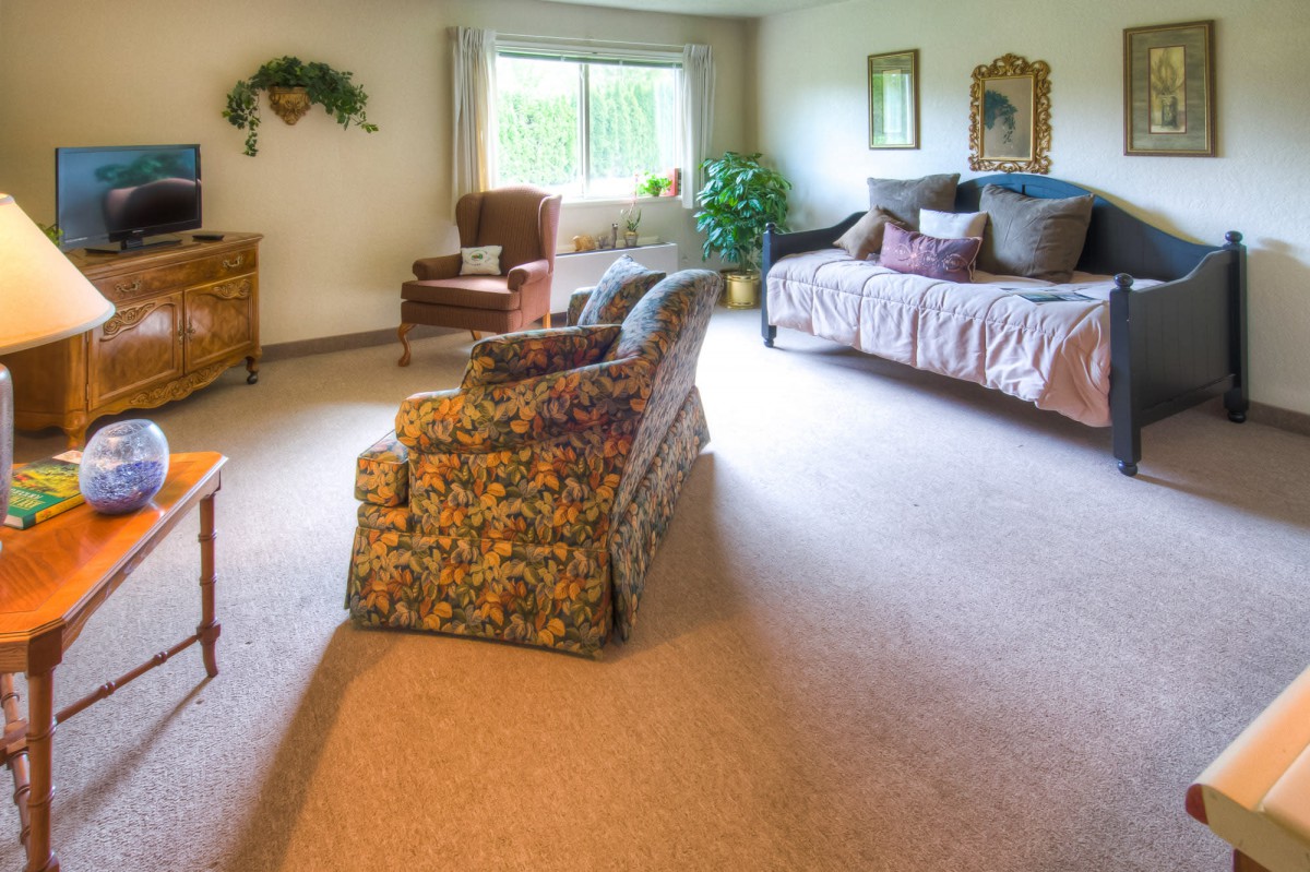 A cozy, traditionally styled living room with a sofa, armchair, and decor.