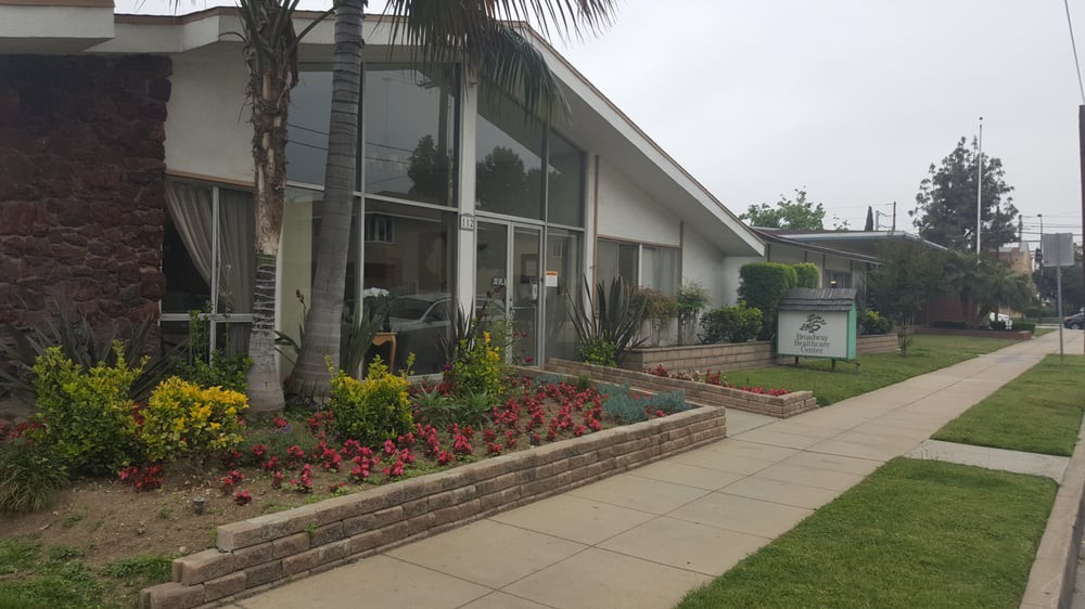 A modern building with large glass windows and landscaped garden area.