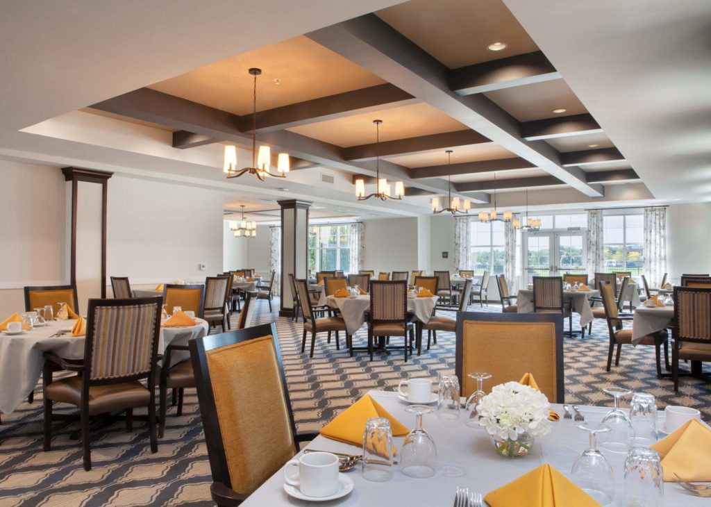 An elegant dining room set with tables, chairs, and chandeliers.