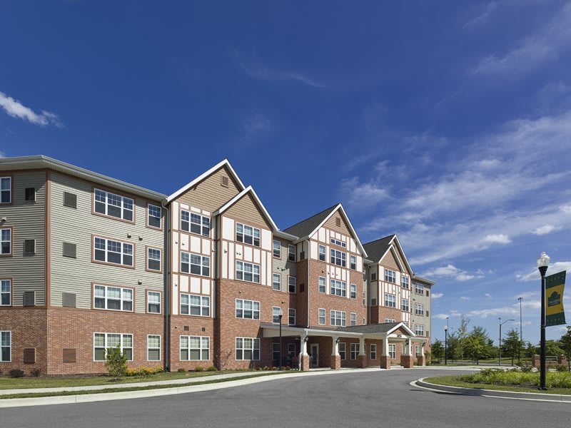 A multi-story residential apartment building under a clear blue sky.