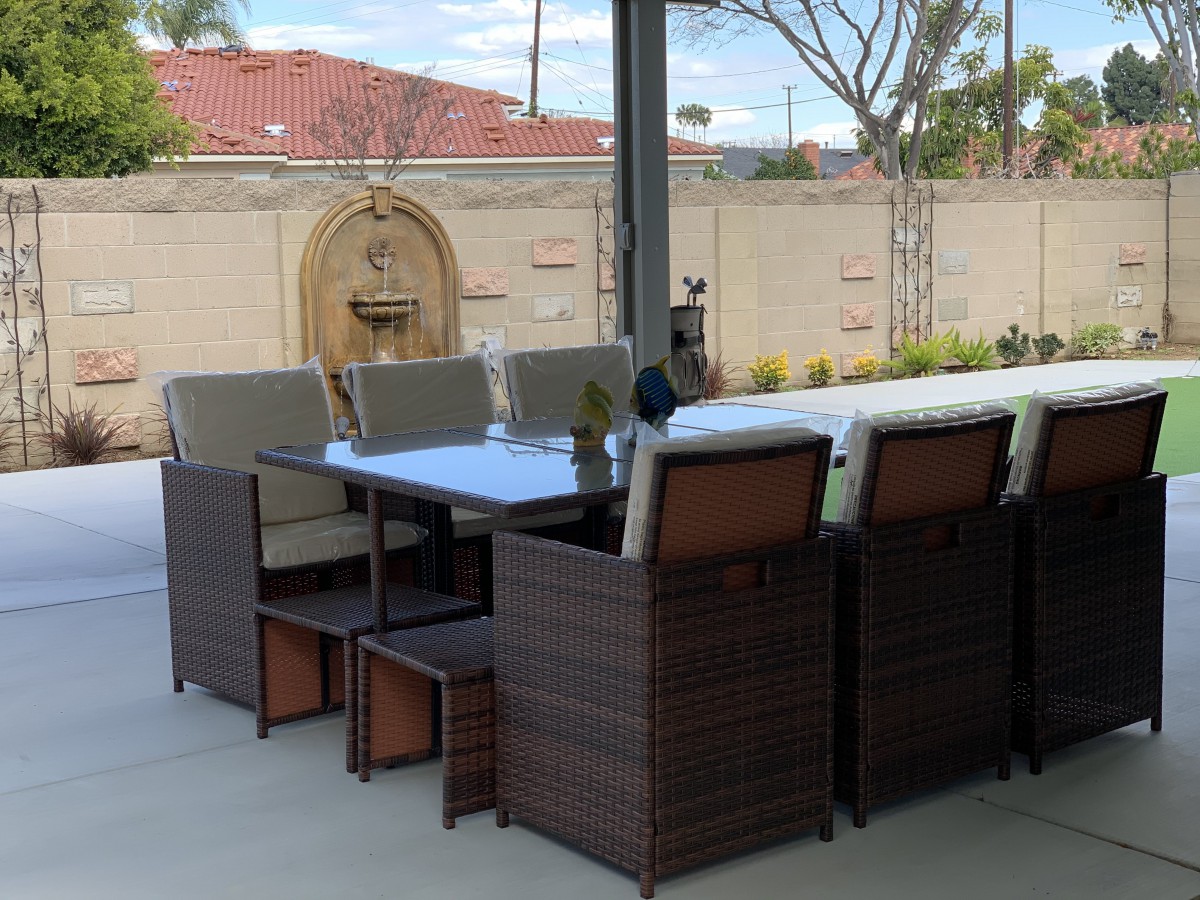 Outdoor patio furniture set with a table and chairs in a backyard setting.