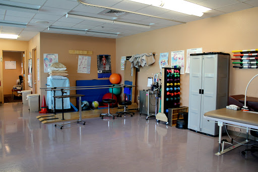 A well-equipped physical therapy room featuring various exercise tools and colorful equipment.