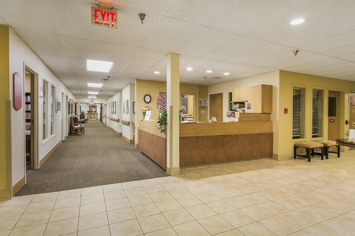 A hospital hallway featuring a reception desk and fluorescent lighting.