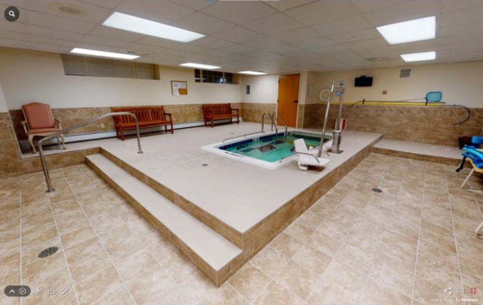 Indoor spa area with a small hot tub and seating for relaxation.