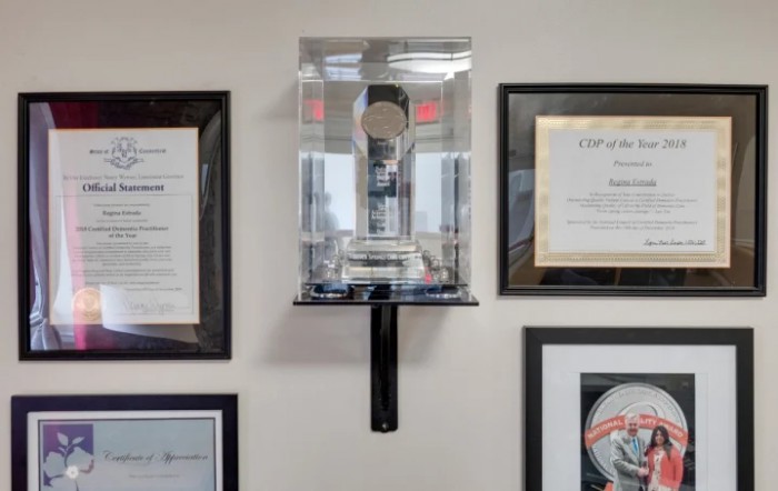 A trophy displayed on an office wall surrounded by framed documents.