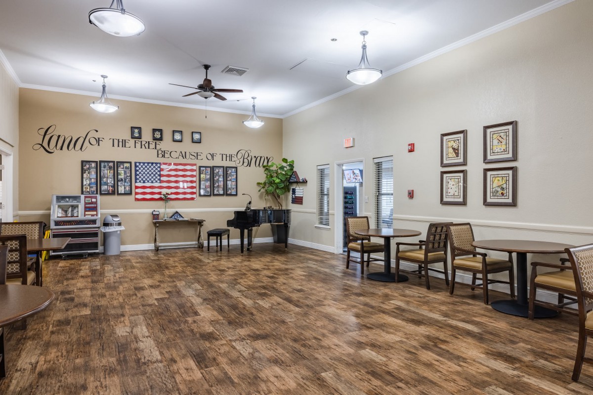 A spacious recreation room featuring a piano, seating area, and patriotic decor.