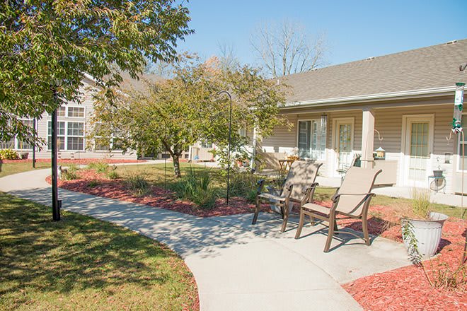 A serene garden with a bench and pathway under a clear blue sky.