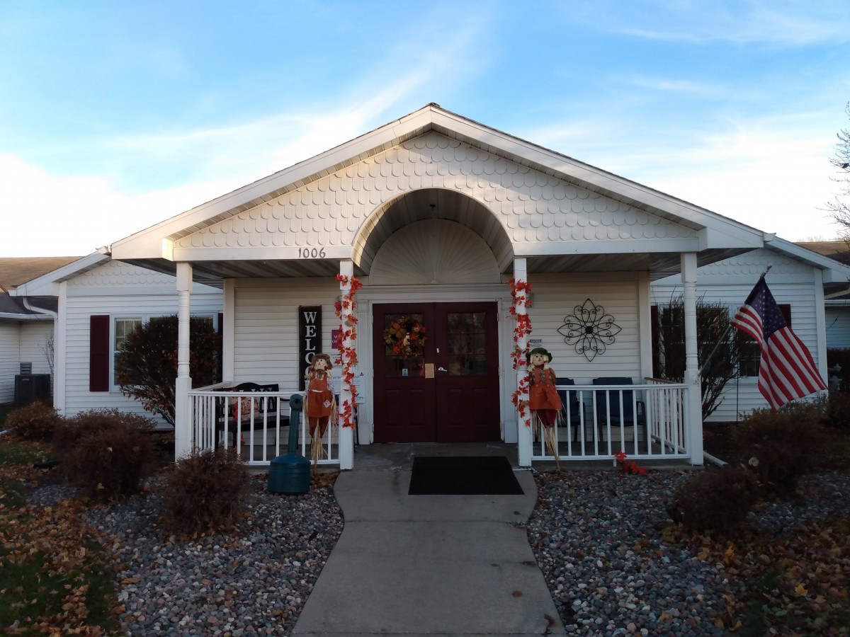 A house with a decorated entrance and porch, featuring autumn-themed decorations.