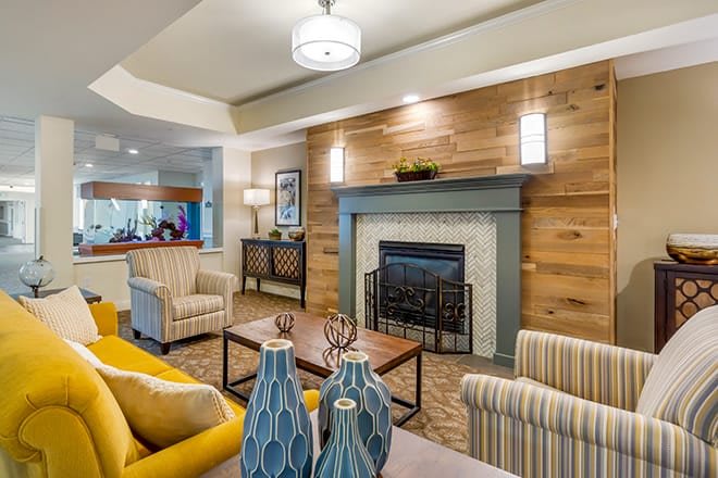 A cozy living room featuring modern decor with a central fireplace, comfortable seating, and stylish vases.