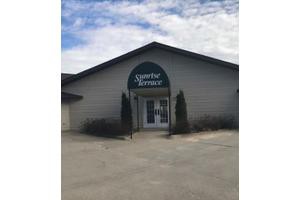 A commercial building with an entrance sign labeled 'Sportsman's Terrace'.