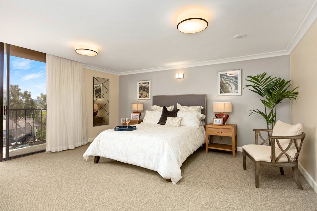 A modern bedroom with elegant decor, featuring a comfortable bed, stylish furniture, and soft lighting.