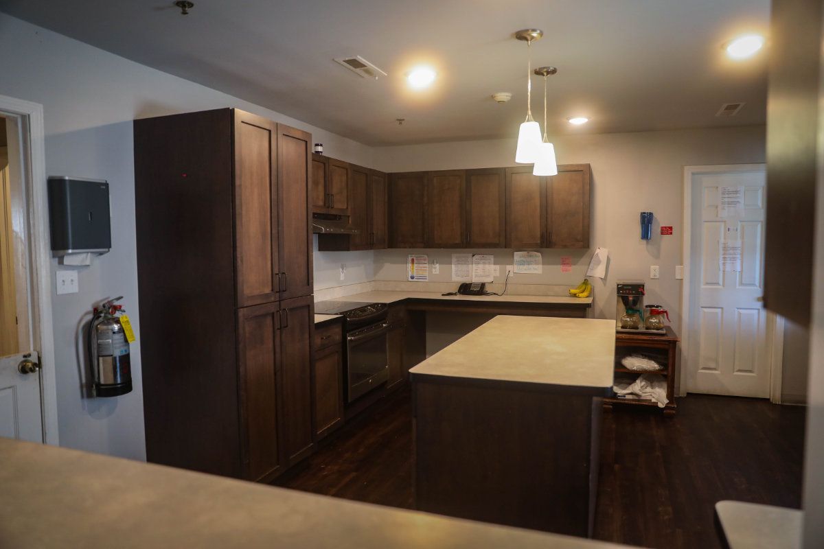 A modern kitchen with wood cabinets, an island, and pendant lighting.