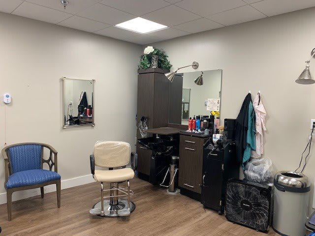 A cozy hair salon with a styling chair and mirror.