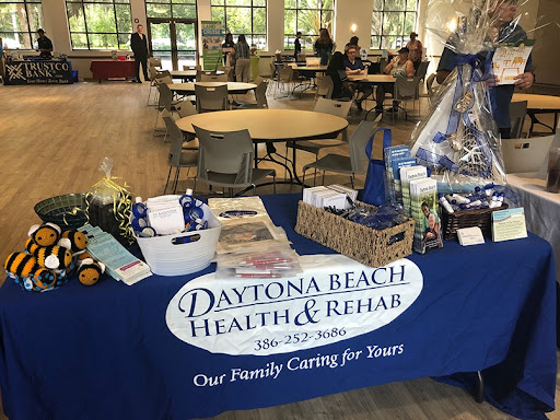A table showcasing promotional materials for Daytona Beach Health & Rehab at a community event.