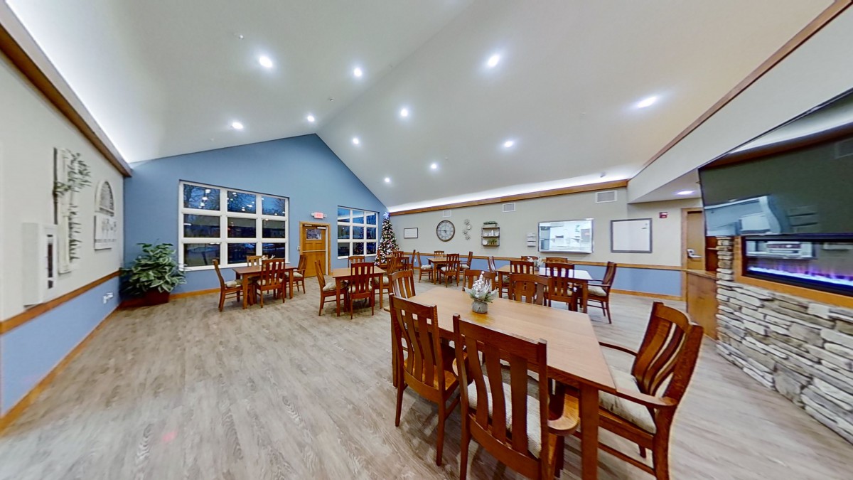 A spacious and well-lit dining area with wooden tables and chairs.