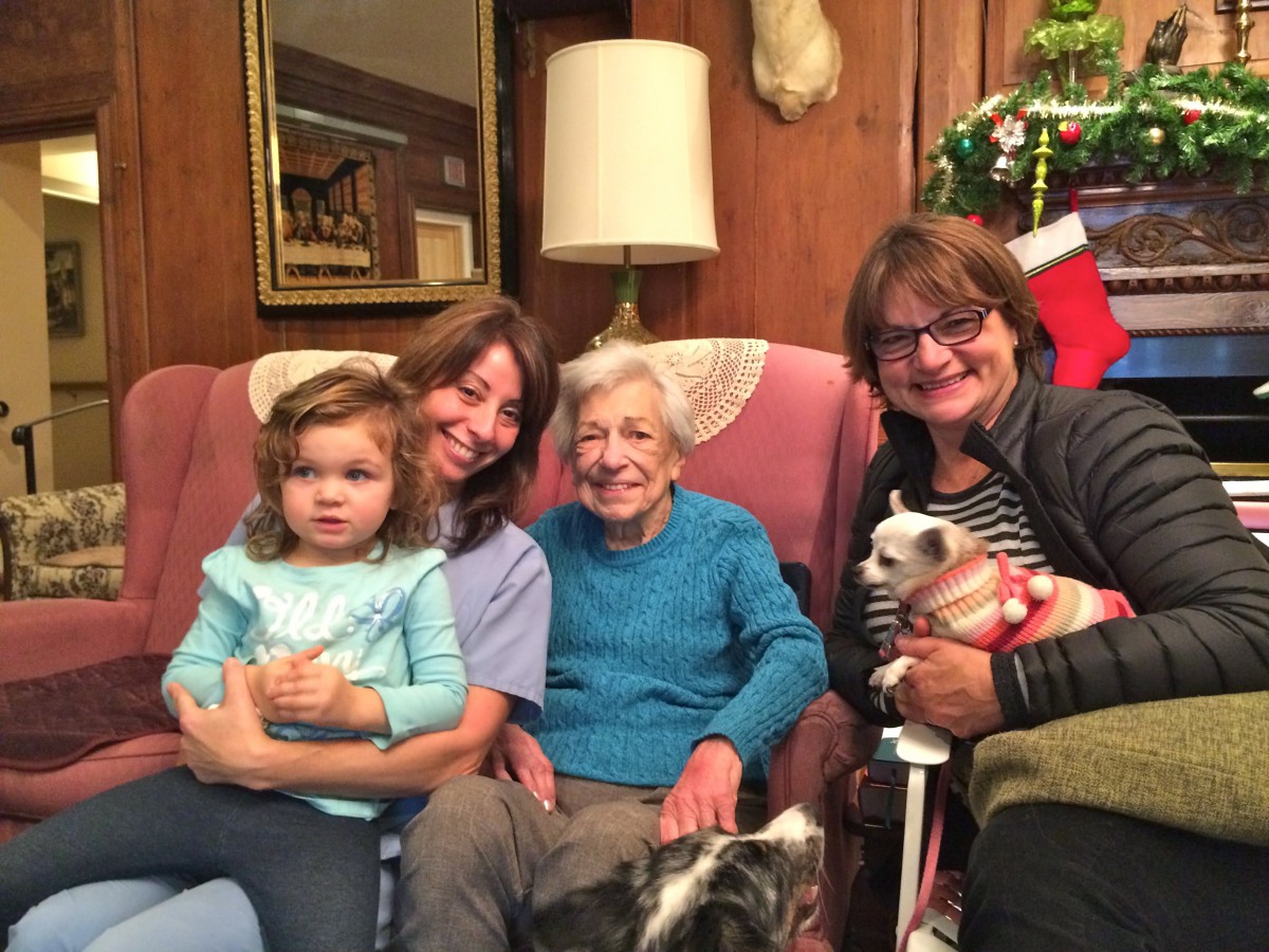 A family enjoying a cozy moment together in the living room, surrounded by holiday decorations.