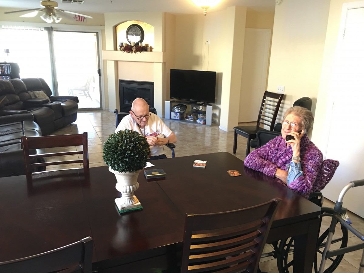 Two people sitting at a dining table in a home setting.